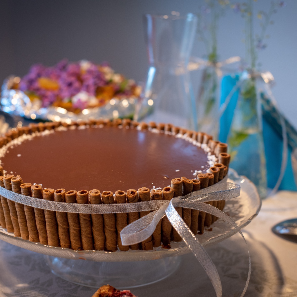 Большой шоколадный торт с трубочками на столе