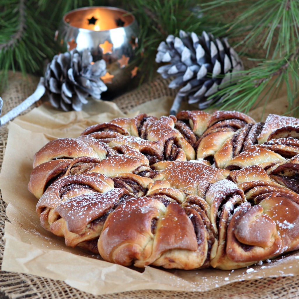 Сдобный венок с вареньем на столе с шишками