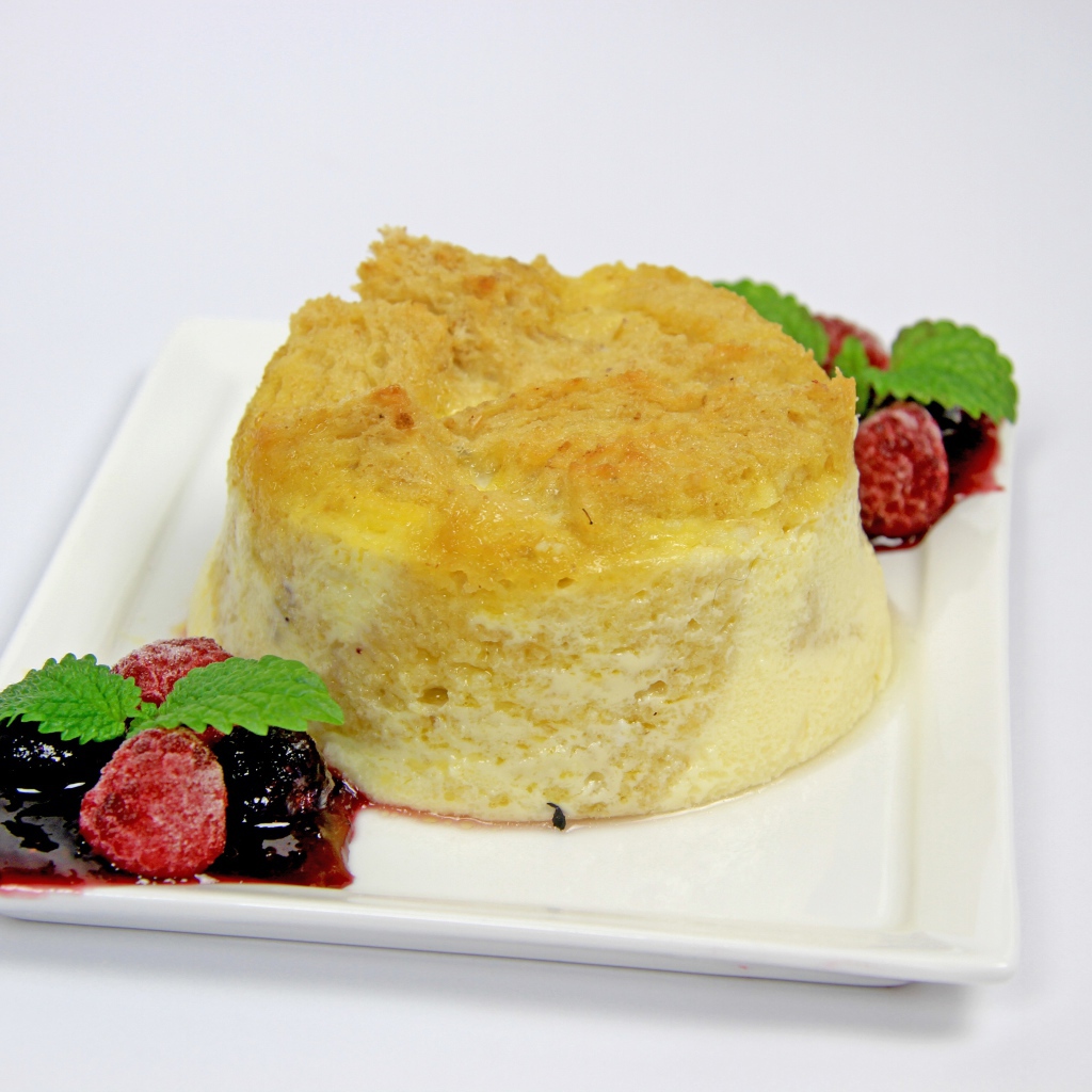 Пирожное на большой белой тарелке с ягодами