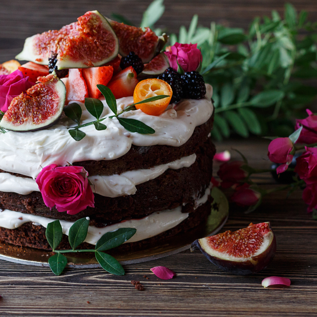 Торт с шоколадными коржами и сливочным кремом украшен ягодами