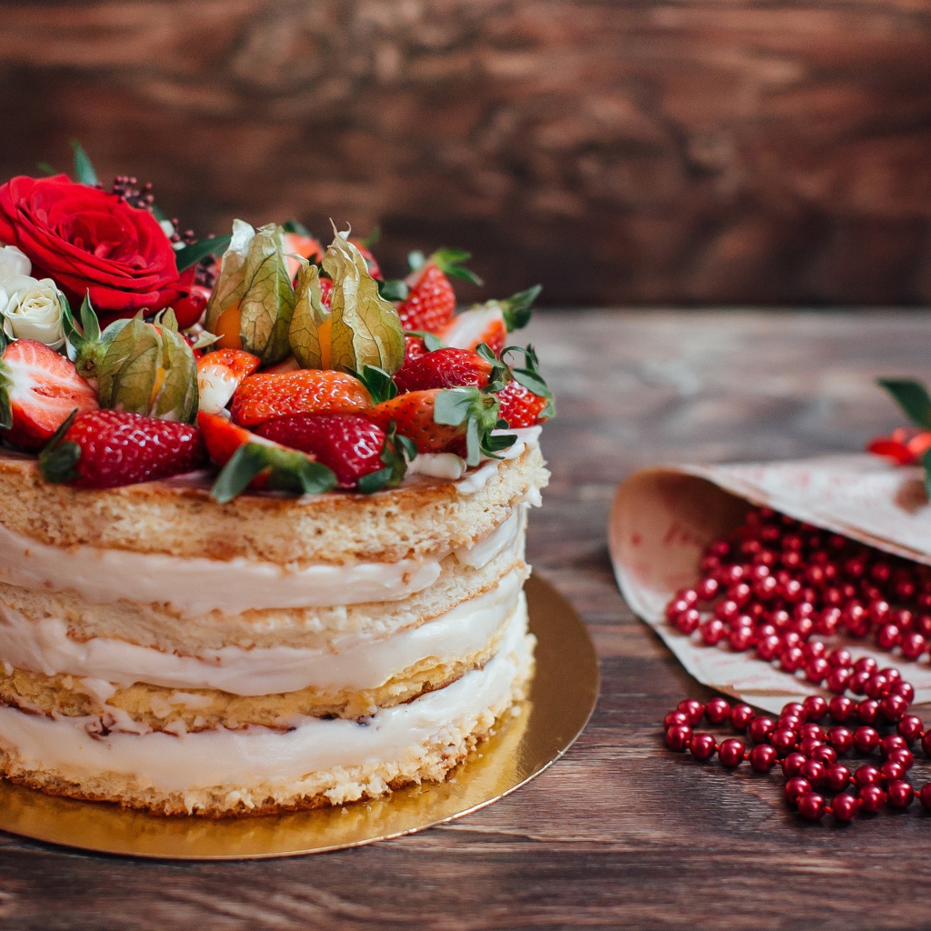 Торт с коржами и ягодным кремом украшен клубникой 