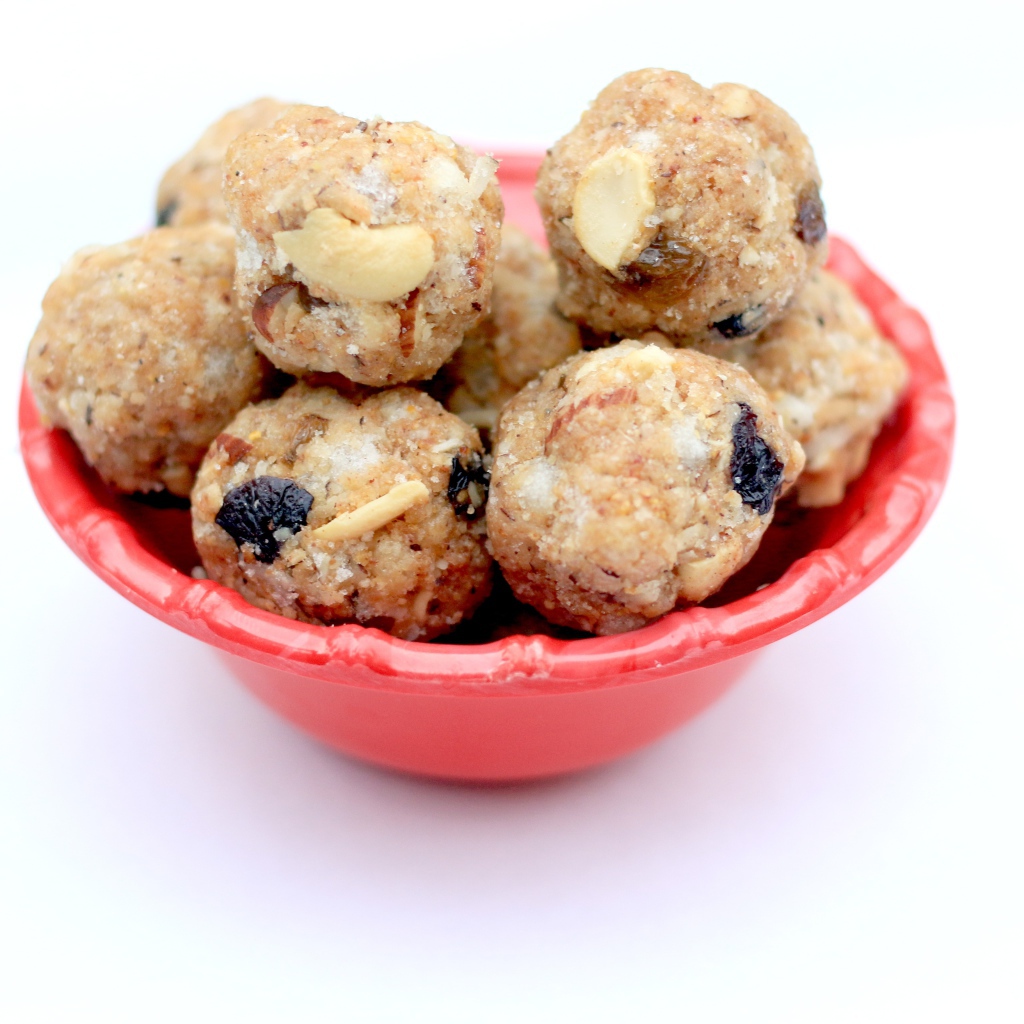 Десерт ладду в красной миске на сером фоне