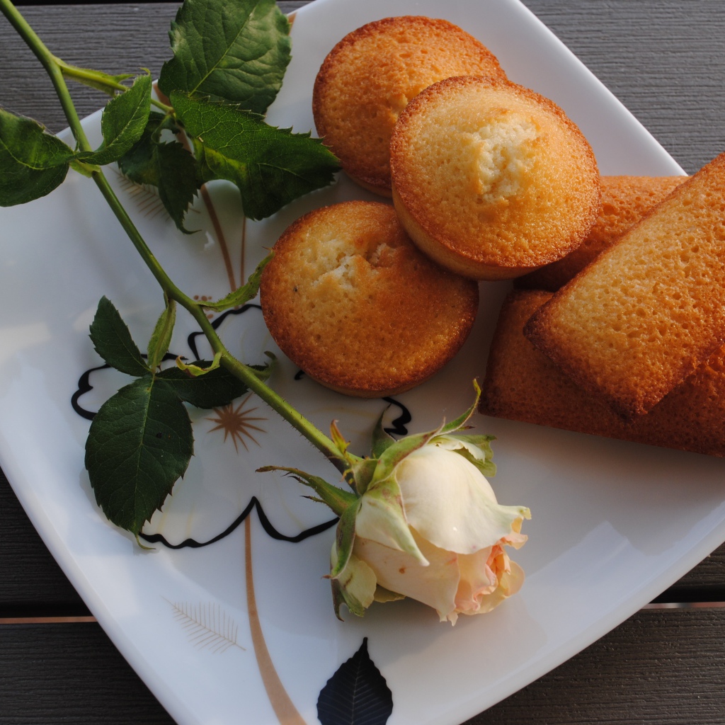 Свежие кексы на белой тарелке с розой