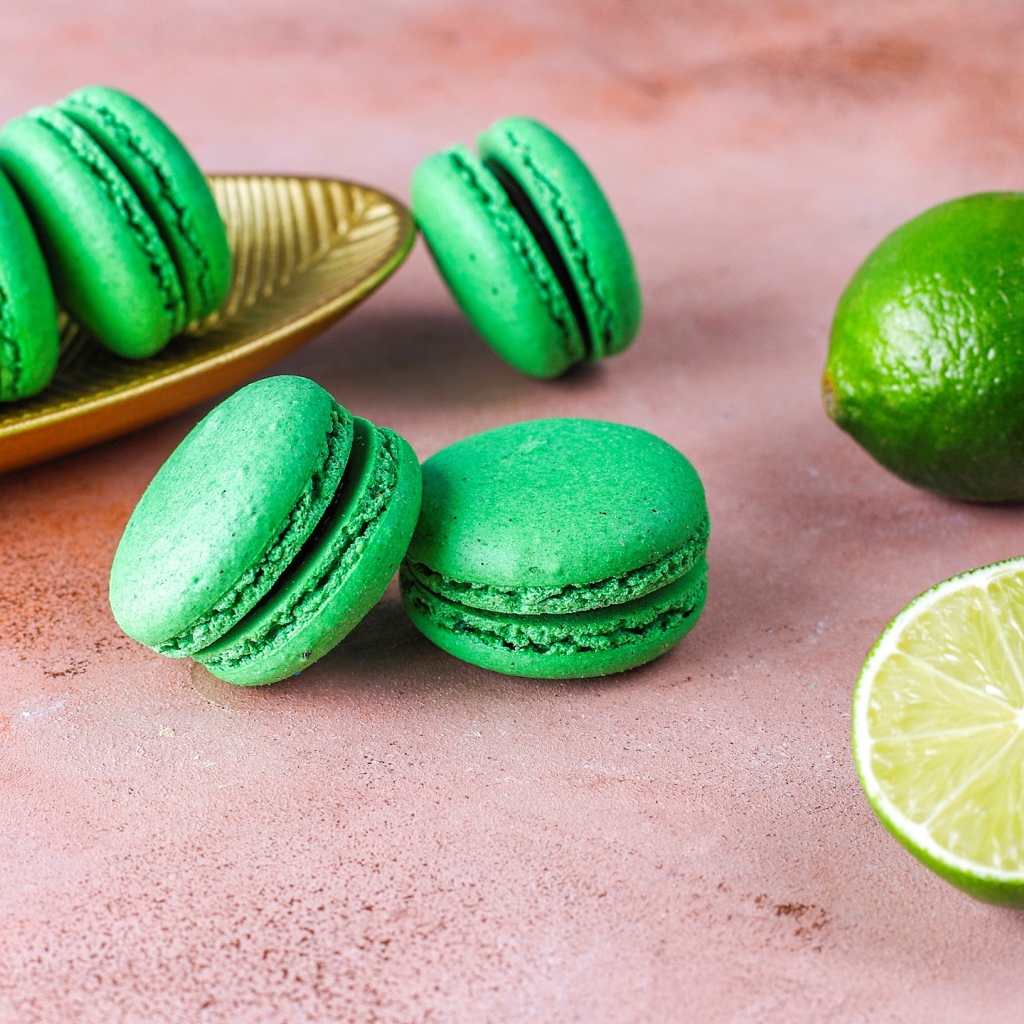 Зеленый десерт макарун на столе с лаймом