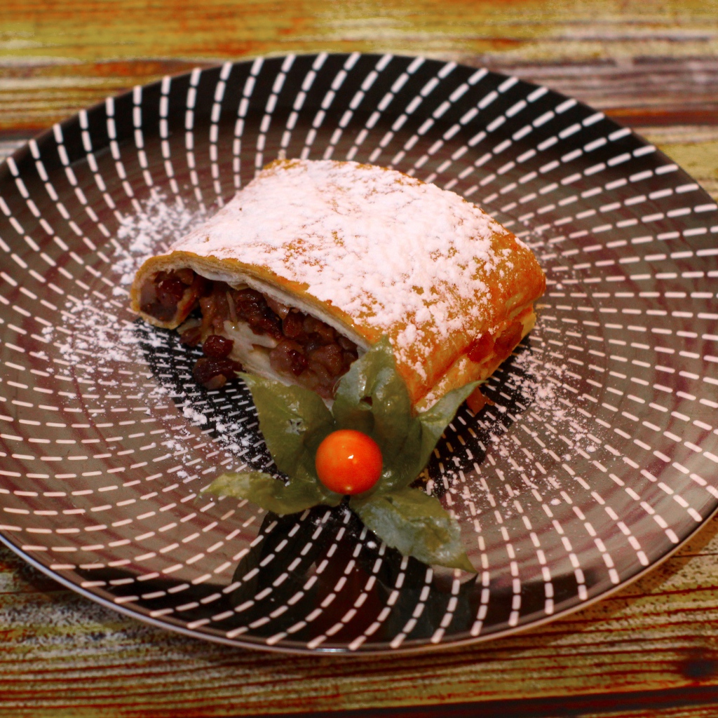 Кусок яблочного штруделя на тарелке 