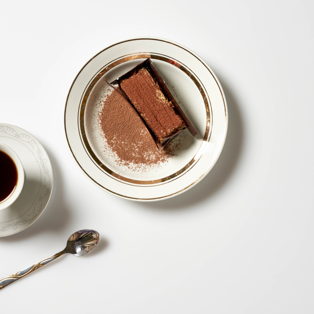 Кусок торта на столе с чашкой кофе 