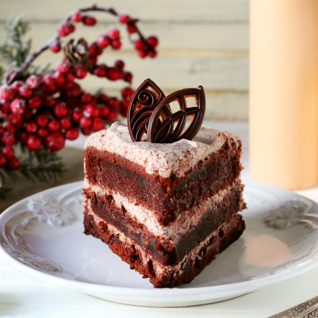 Кусок шоколадного торта на белой тарелке на столе