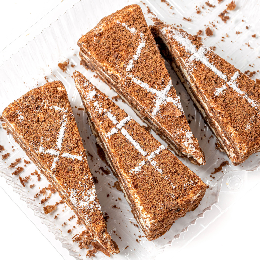 Куски аппетитного медового торта на белом фоне