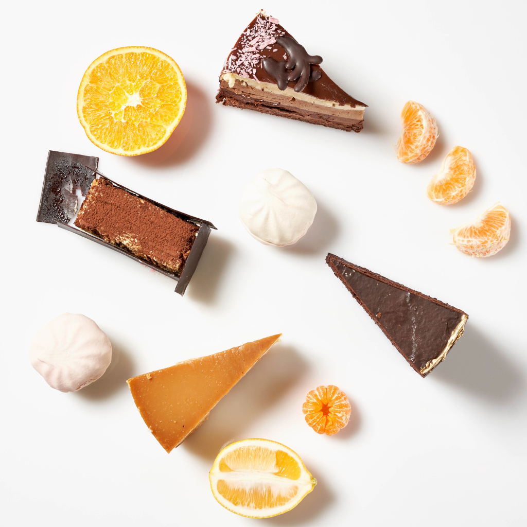 Куски торта на белом фоне с мандарином и лимоном