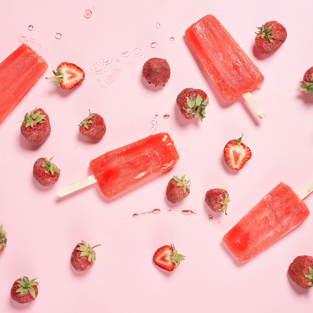 Фруктовое мороженое на розовом фоне с ягодами клубники 
