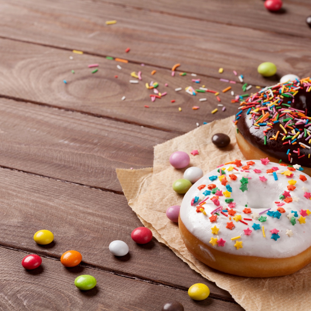 Сладкие пончики с глазурью на столе с конфетами