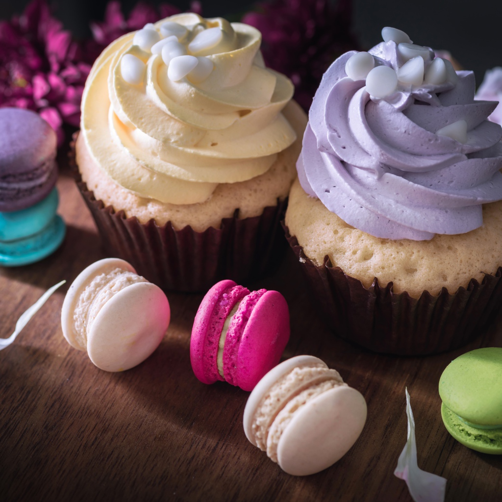 Два капкейка на столе с десертом макарун