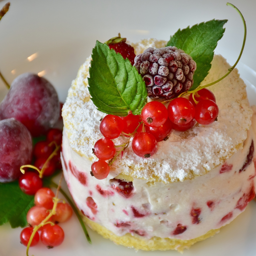 Пирожное со взбитыми сливками украшено ягодами