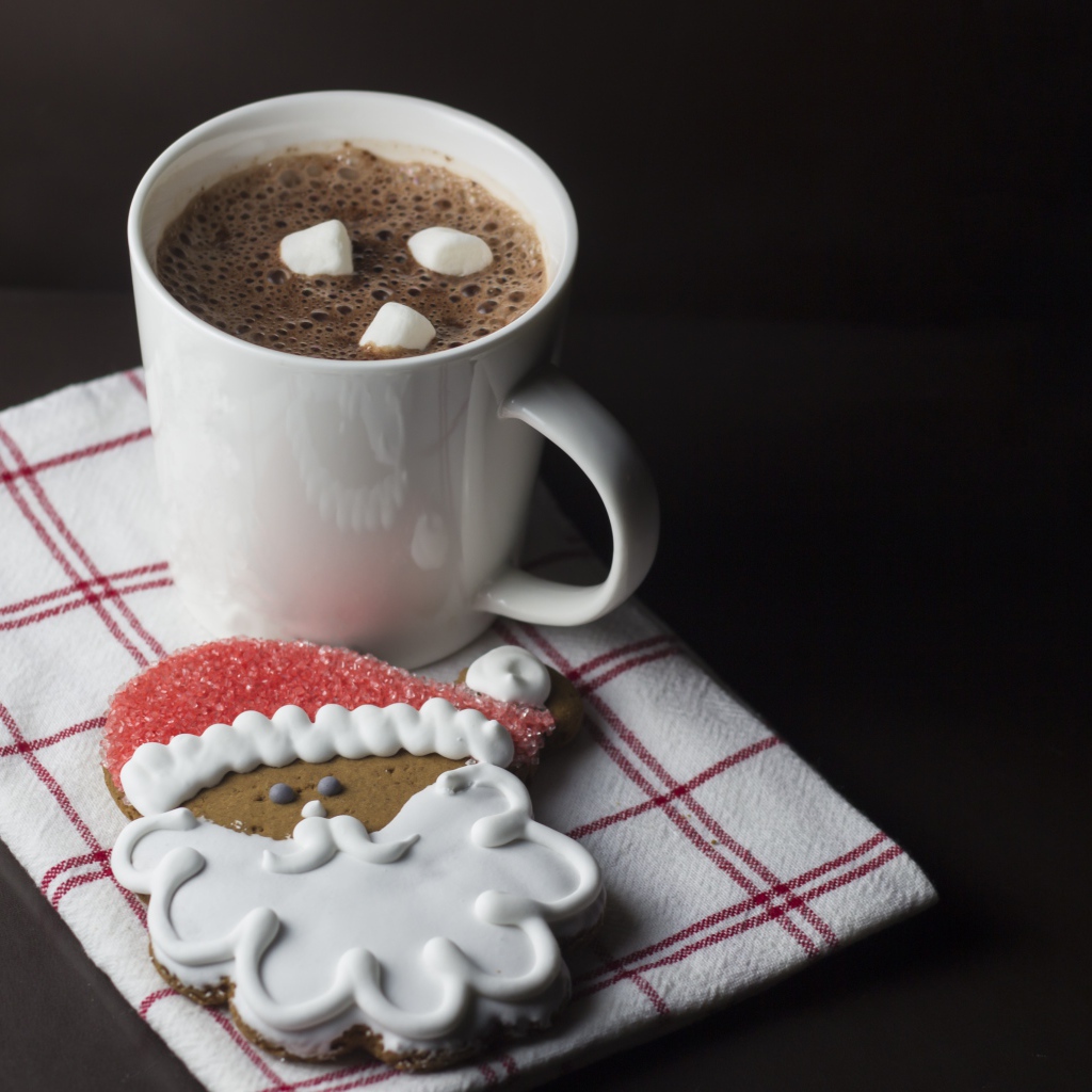 Чашка кофе с праздничным печеньем на черном фоне