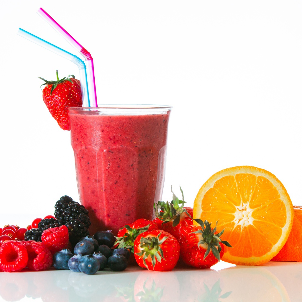 Стакан свежего смузи на столе с ягодами