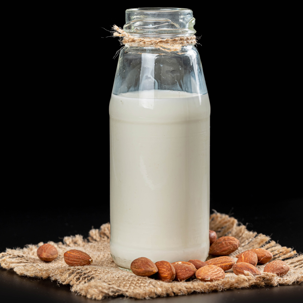 Молоко с миндалем на черном фоне