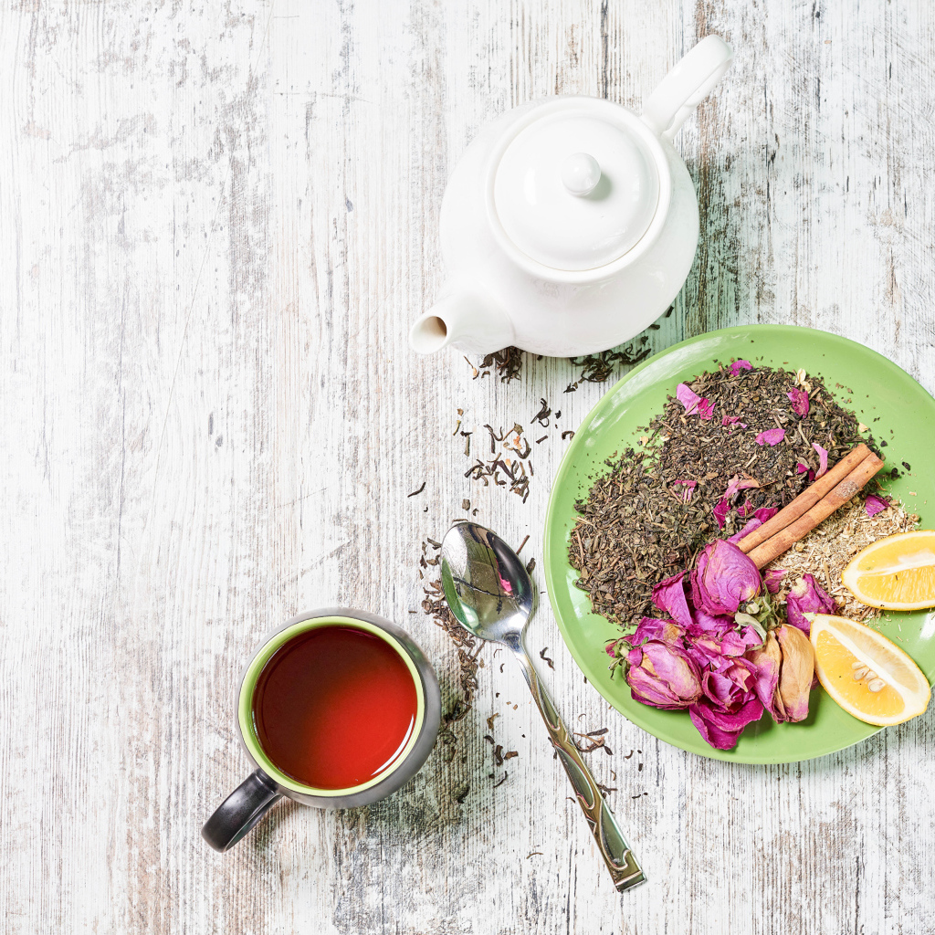 Чай на тарелке с кусочками лимона на столе