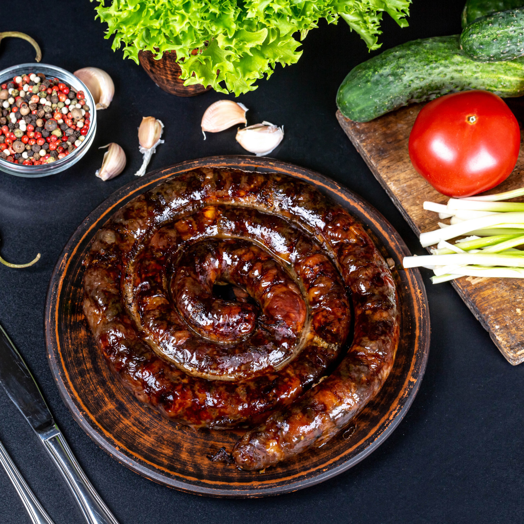 Appetizing homemade sausage on the table with spices and vegetables