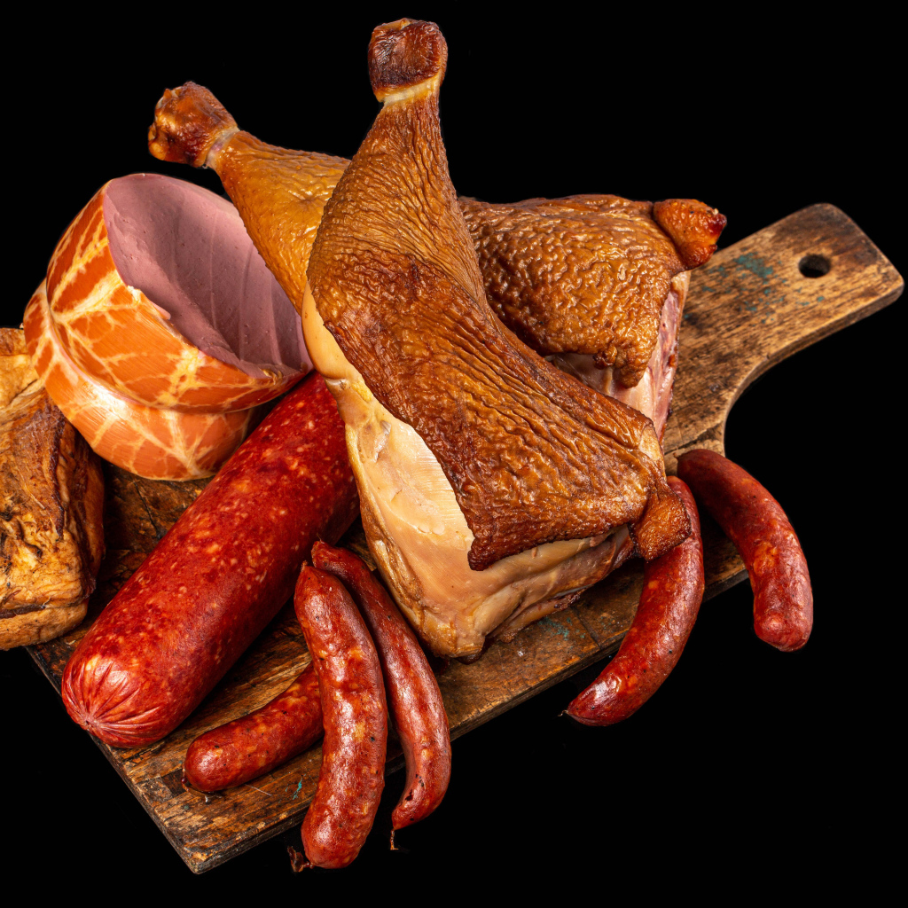 Appetizing smoked meats and sausage on a black background