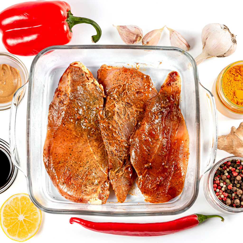 Маринованное мясо на столе со специями и соусом