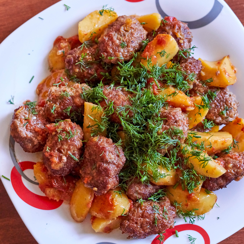 Фрикадельки с картофелем и укропом на белой тарелке