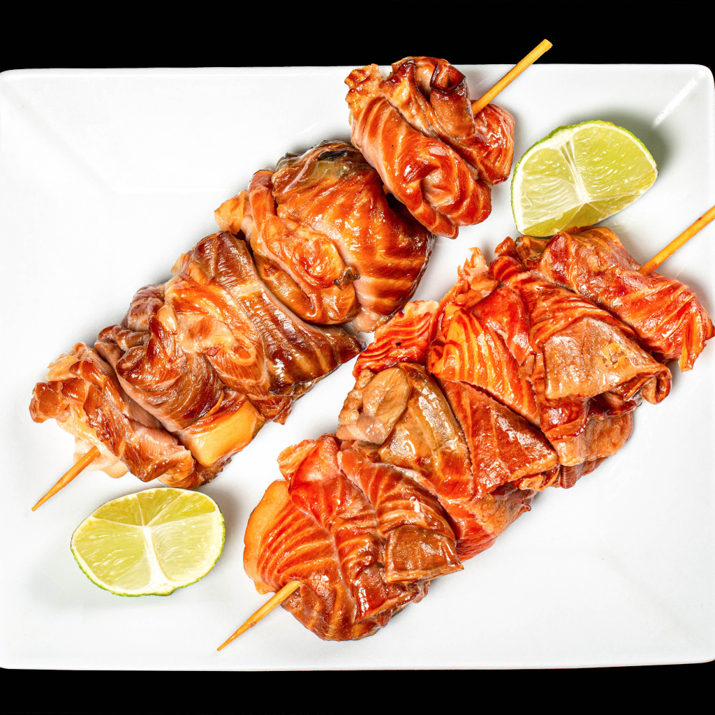 Шашлык на шпажках на белой тарелке с лимоном