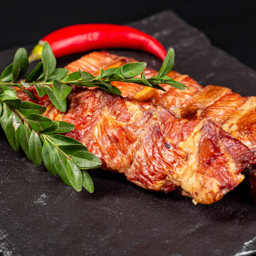 Копченые свиные ребрышки с зелеными листьями