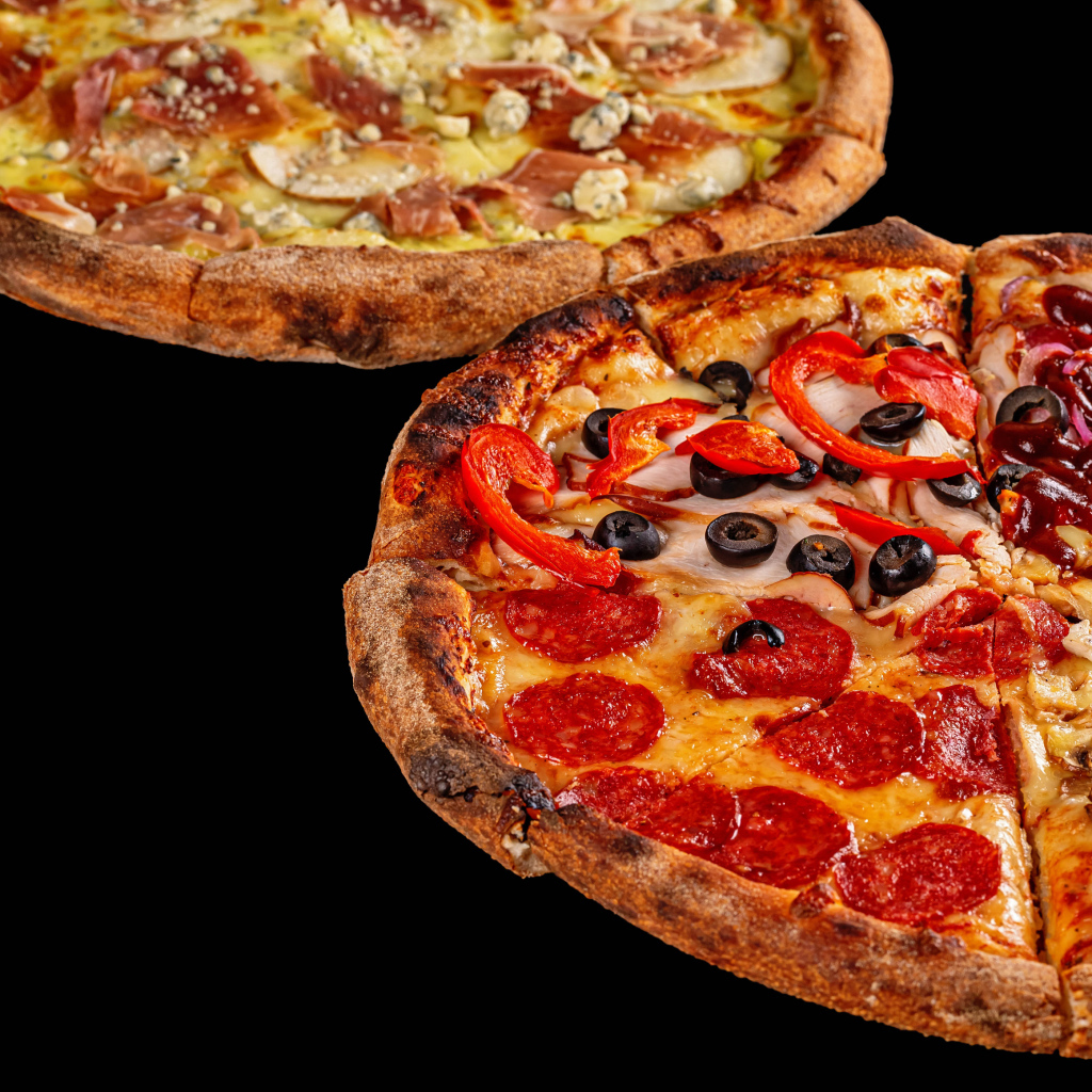 Две аппетитные пиццы на черном столе