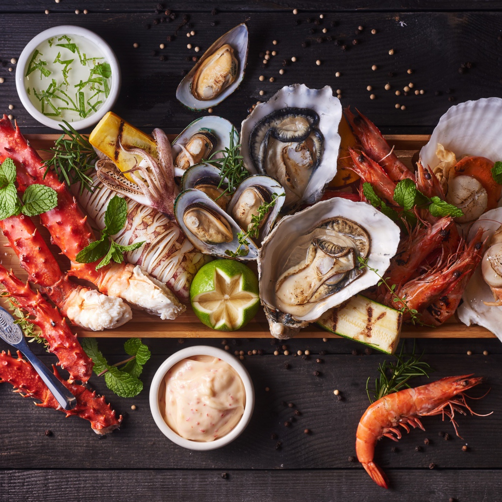 Аппетитные готовые морепродукты на столе с соусом