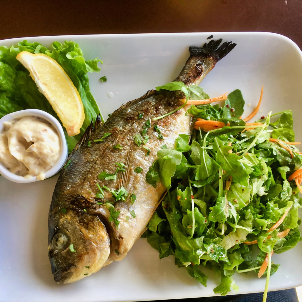 Жареный карась на тарелке с салатом 