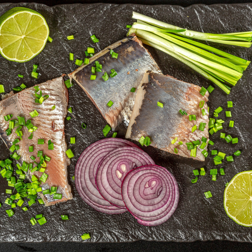 Куски сельди с луком и кусочками лимона
