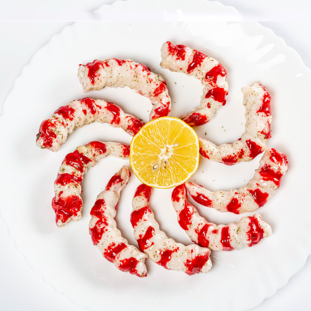 Тигровые креветки на тарелке с лимоном на белом фоне 