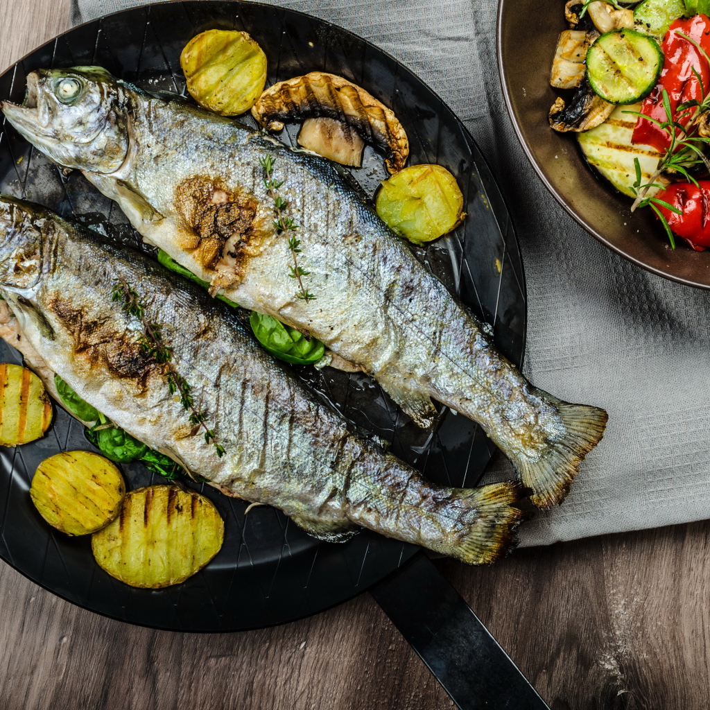 Две рыбины на сковороде с овощами