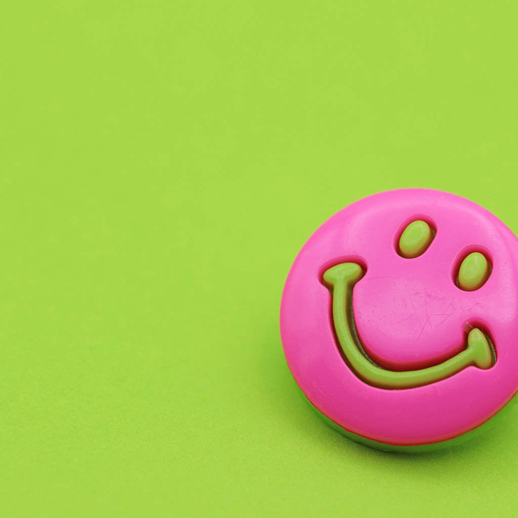 Розовый смайл на зеленом фоне