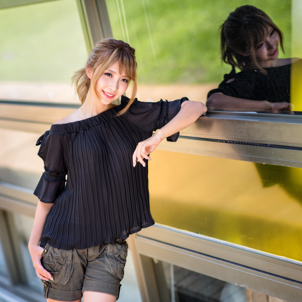 Девушка азиатка в черной блузке у окна