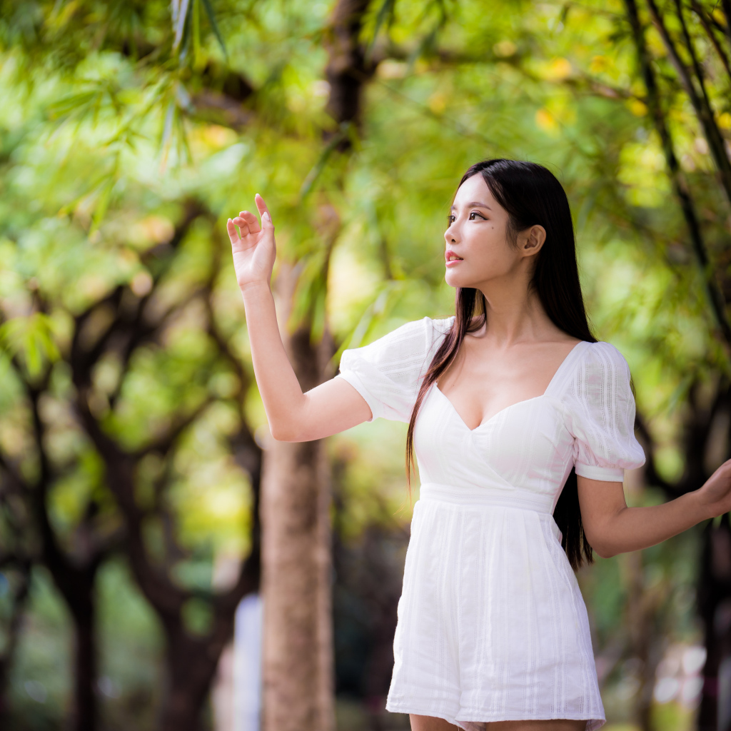 Девушка азиатка в белом платье у дерева