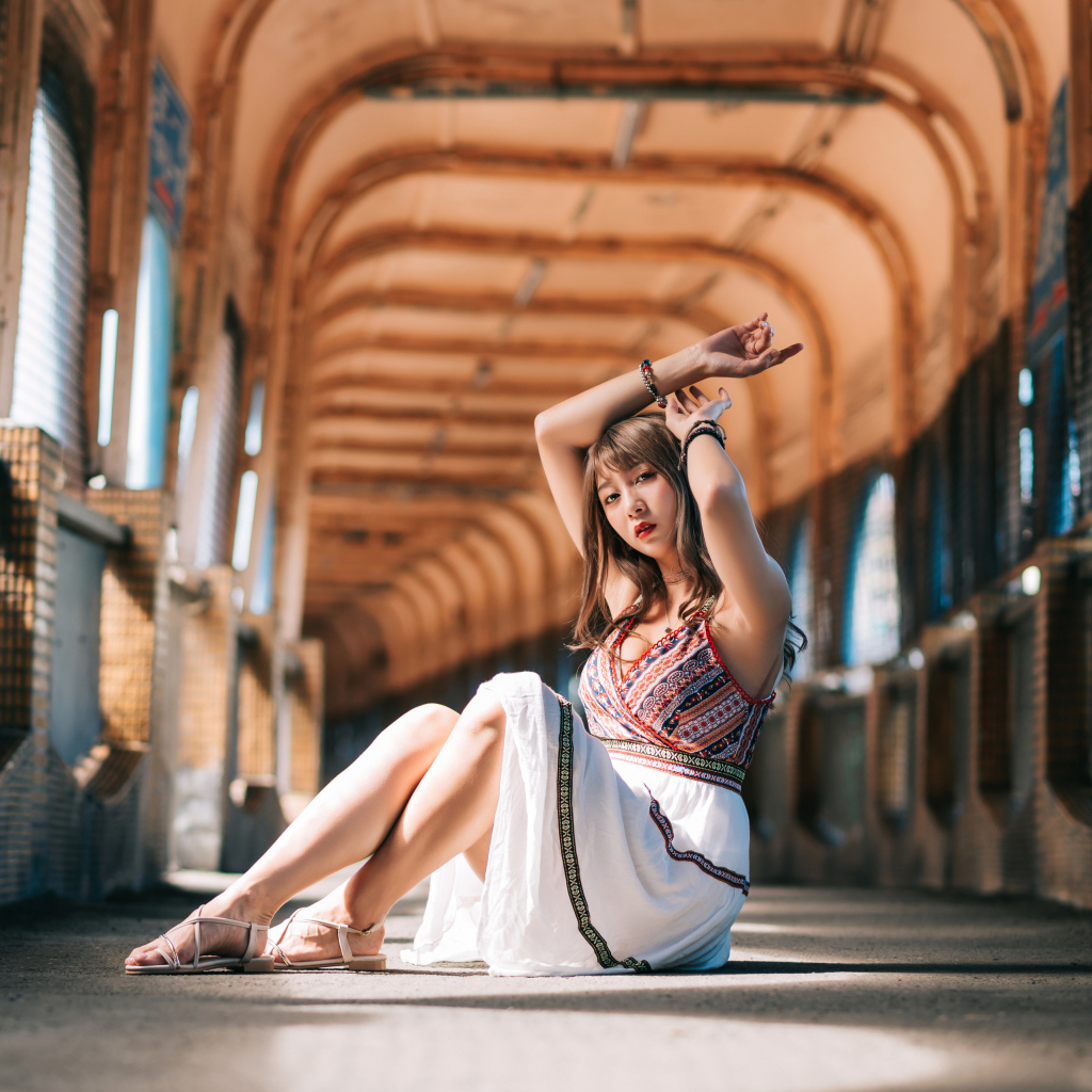 Девушка азиатка сидит в переходе 