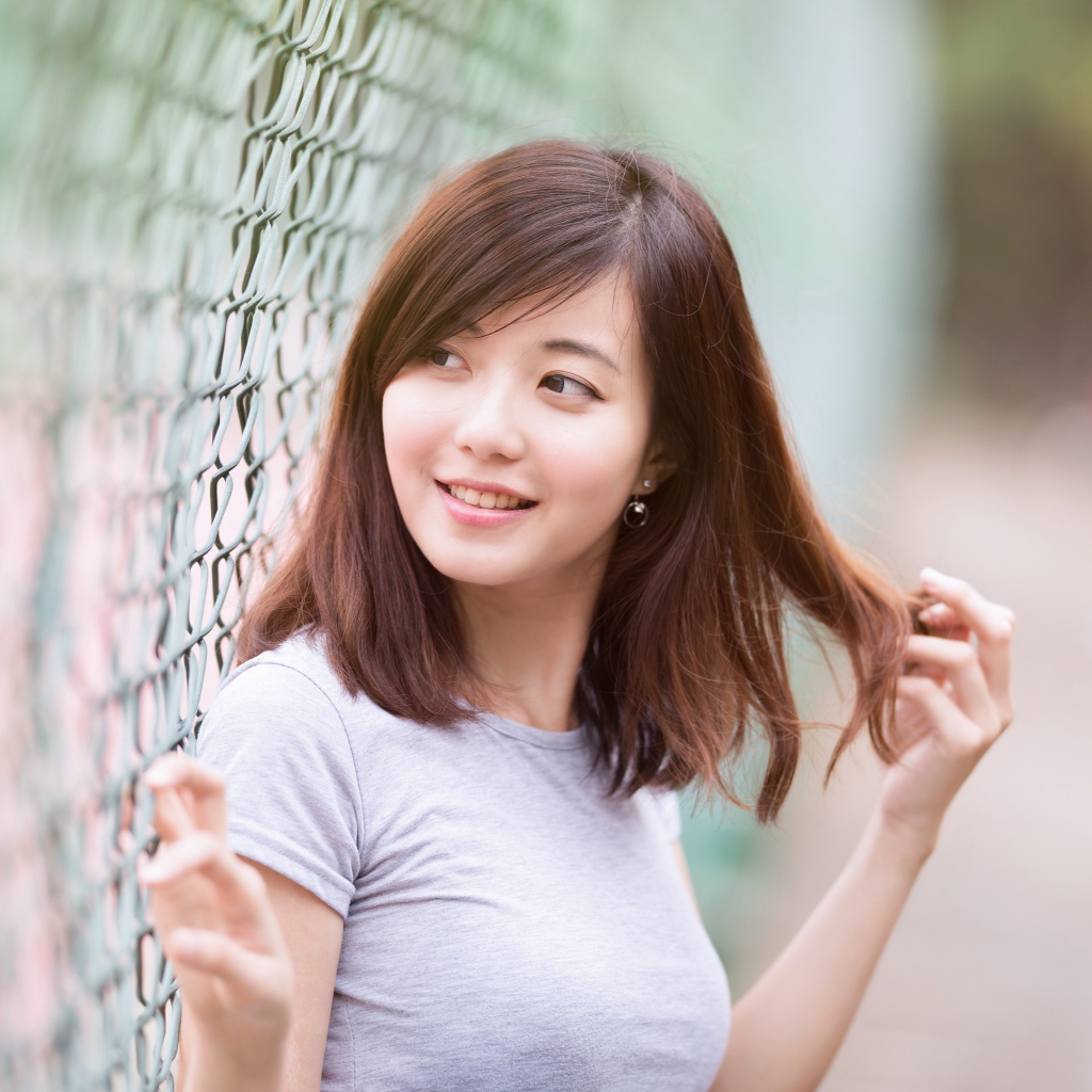Asian girl with a cute smile stands at the net