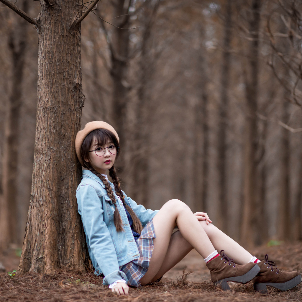 Девушка азиатка школьница сидит под деревом