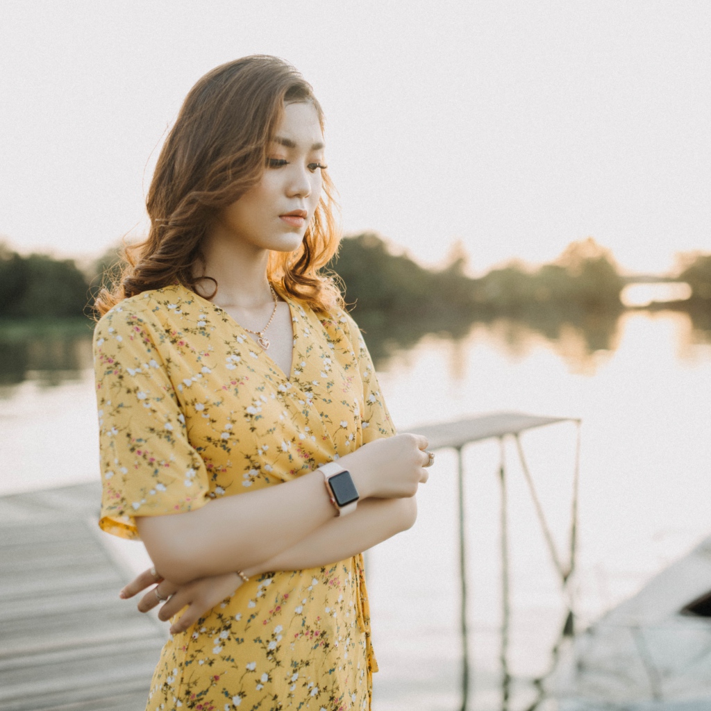 Красивая девушка азиатка стоит у реки 