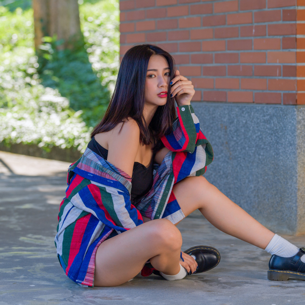 Красивая азиатка в рубашке у стены