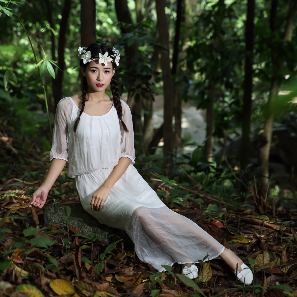 Красивая девушка азиатка в белом платье  в лесу