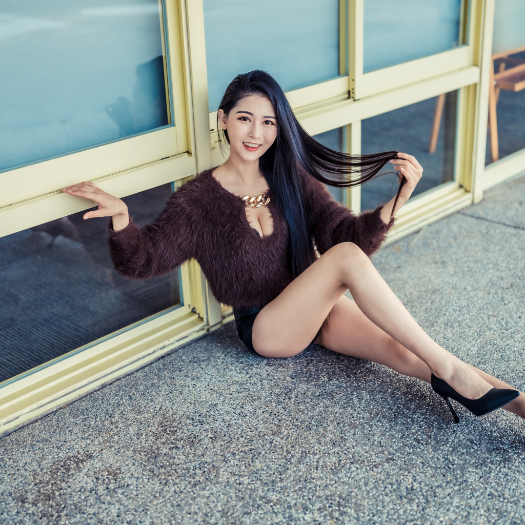 Красивая девушка азиатка в черных туфлях на земле 