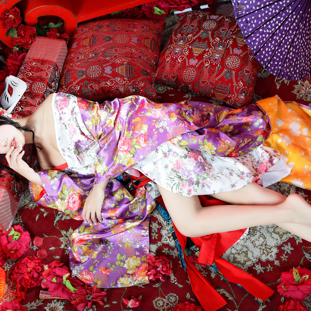 Красивая девушка азиатка в кимоно лежит на полу