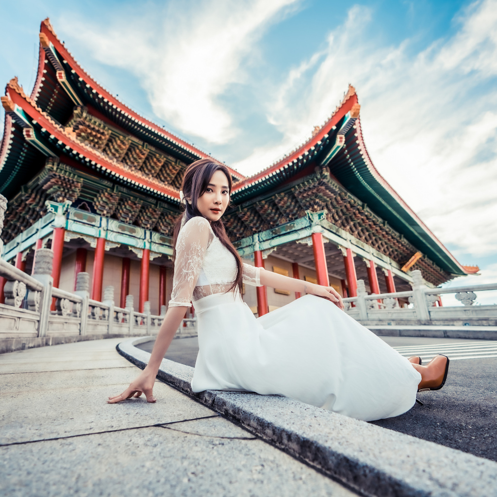 Красивая азиатка в белом платье на фоне храма