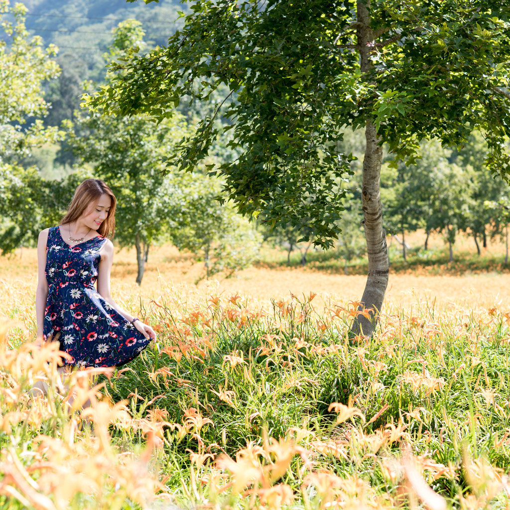 Красивая азиатка гуляет по высокой траве