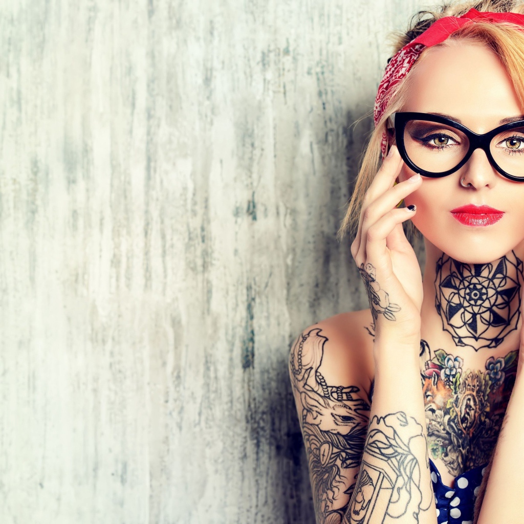 Красивая блондинка в очках с татуировками на теле