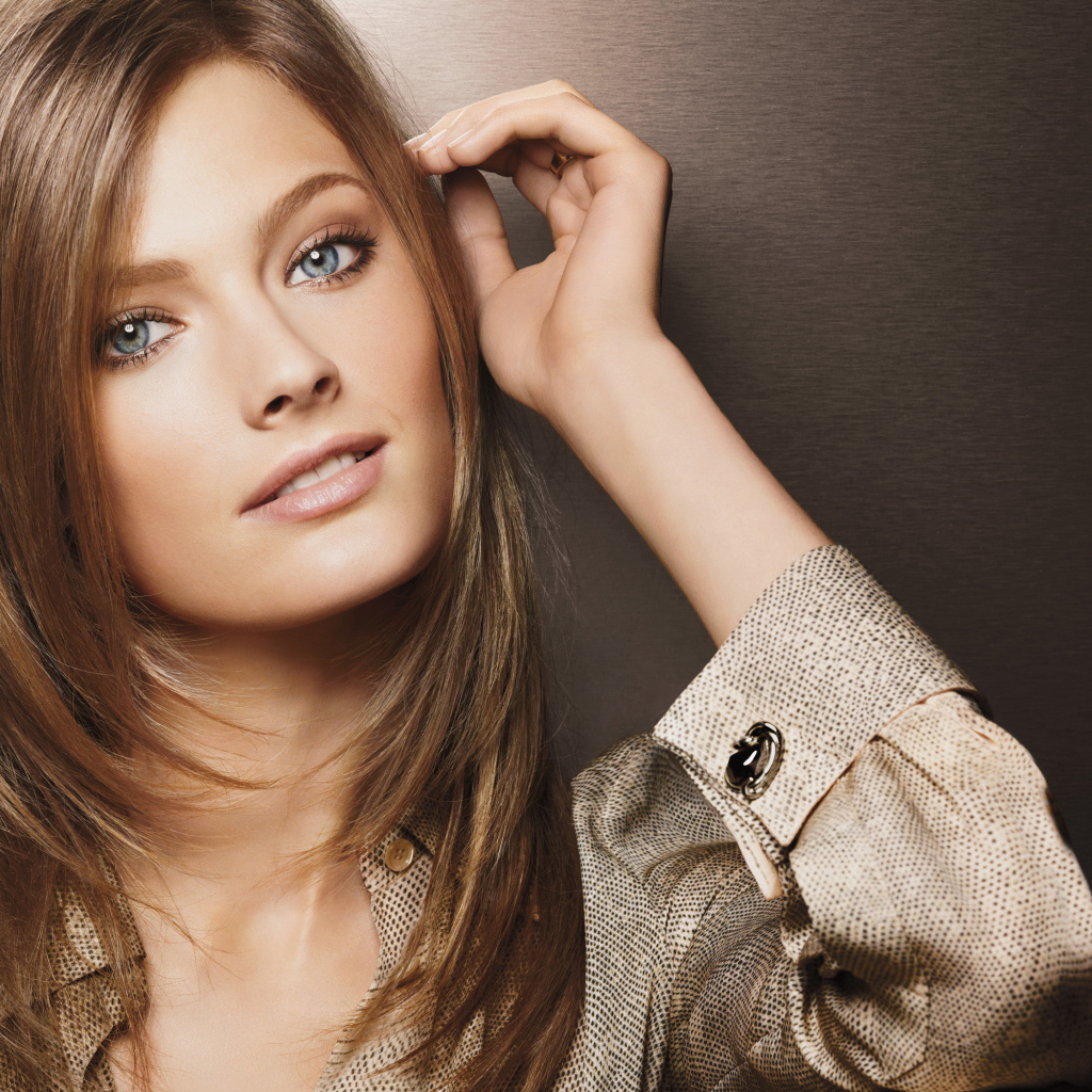 Beautiful blue-eyed girl in a shirt on a brown background