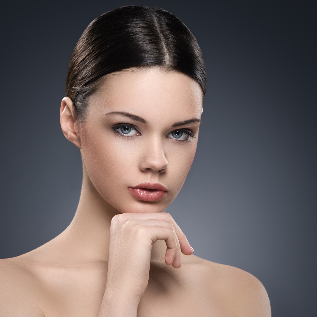 Красивая голубоглазая девушка на сером фоне 