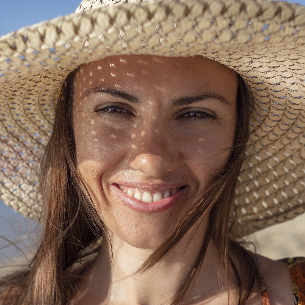 Красивая кареглазая девушка в большой соломенной шляпе 